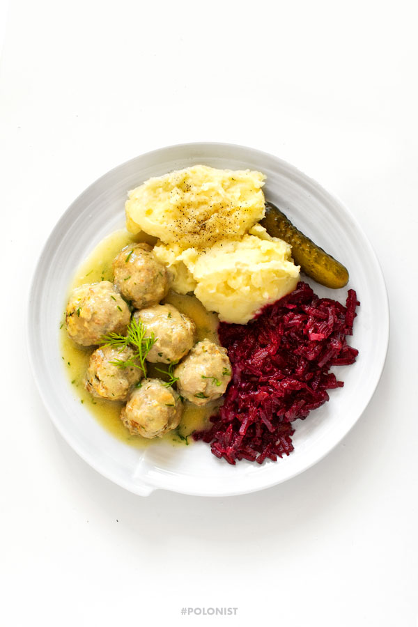 Polish meatballs (Pulpety0 in dill sauce, served with mash potatoes and beetroot salad on a white plate, on a white background. Top view / view from above.