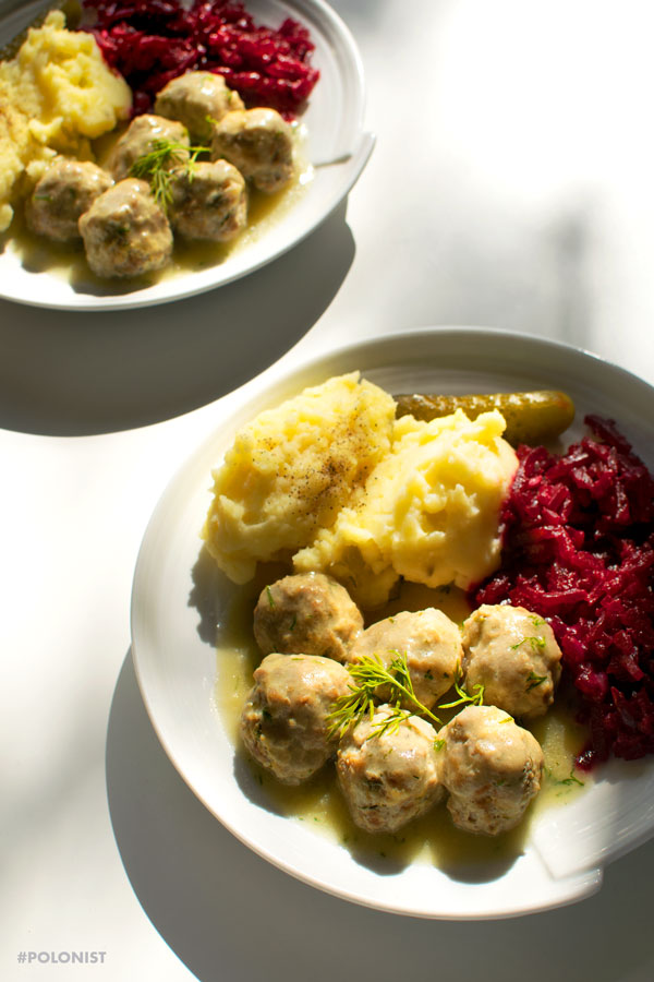 Polish meatballs (Pulpety0 in dill sauce, served with mash potatoes and beetroot salad on a white plate, on a white background. Two plates.