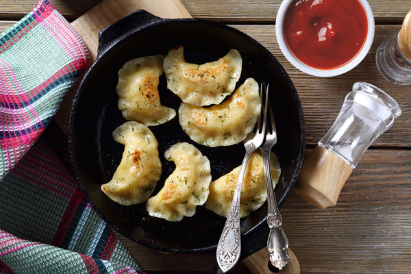Pierogi served with ketchup sauce for dipping