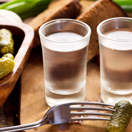Two shots of Polish vodka served with pickles