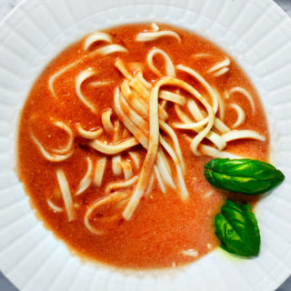 Polish style Tomato Soup with Noodles served on a white plate