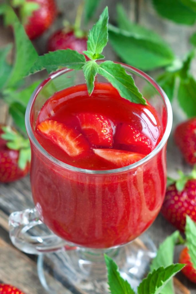 Polish-style Strawberry Kisiel (Kissel) in a dessert glass, served with fresh strawberries.