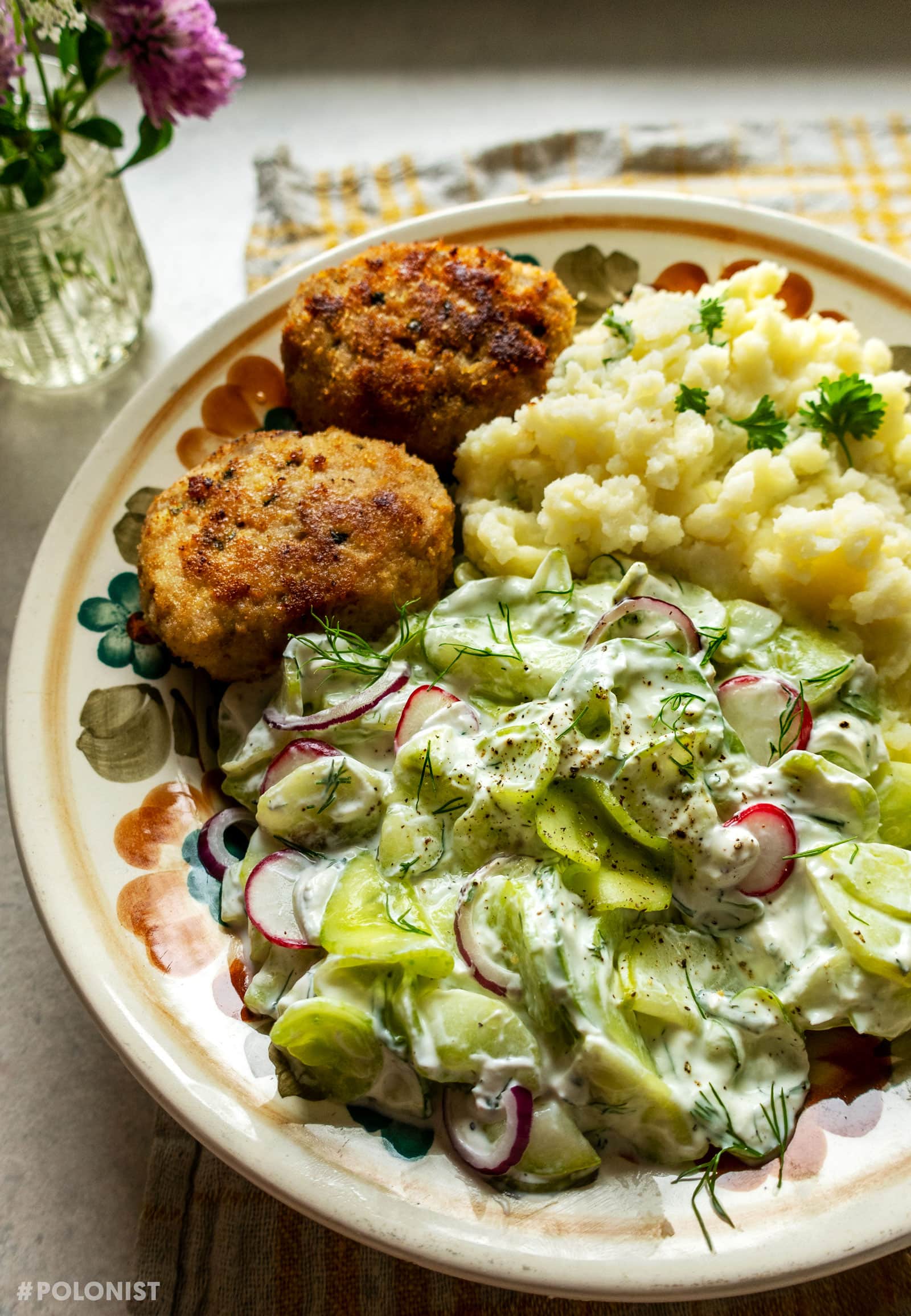 Mizeria (Polish cucumber salad) served with mashed potatoes and pork patties (kotlety mielone)