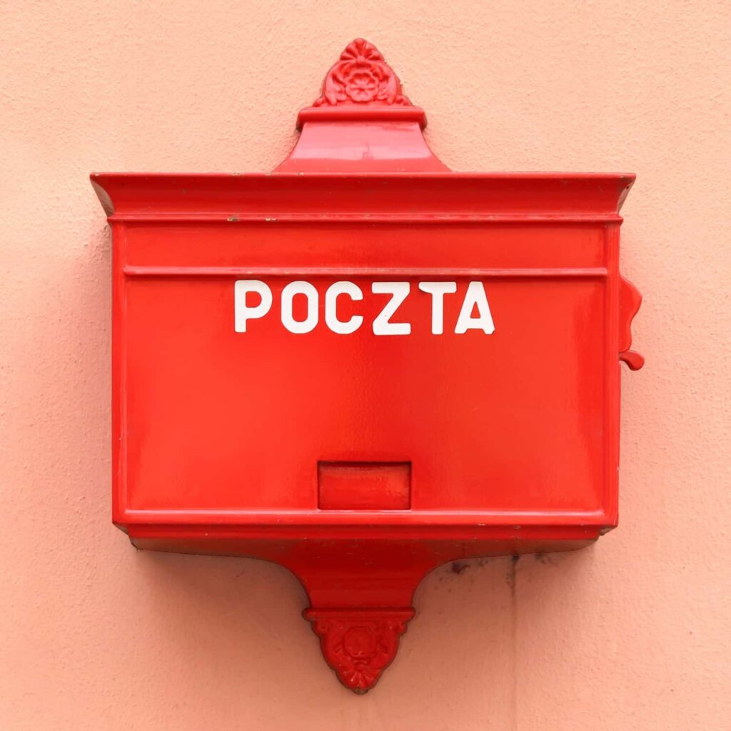 Red vintage postbox in Wrocław, Poland, wall-mounted.